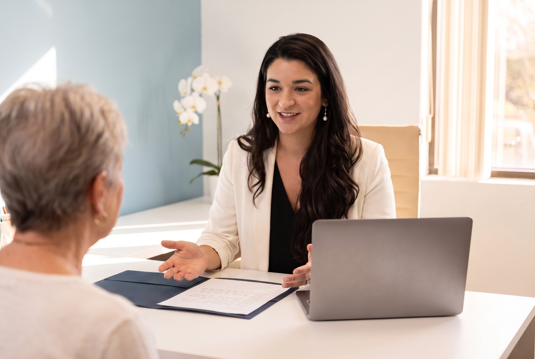Noilan Segal reviewing coverage options with a client at her desk